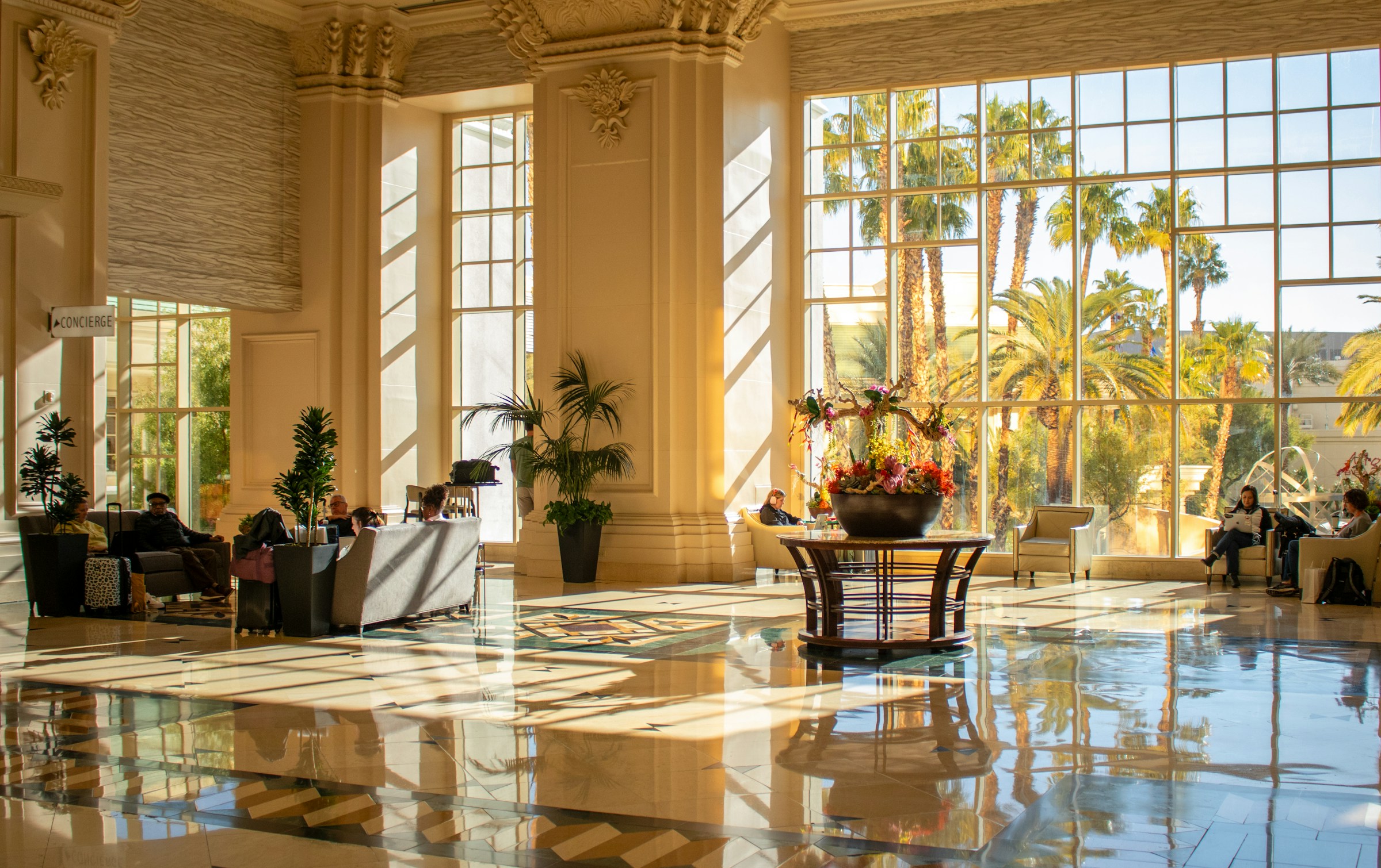Sunlight streaming through tall windows across a spacious lobby and polished marble floor